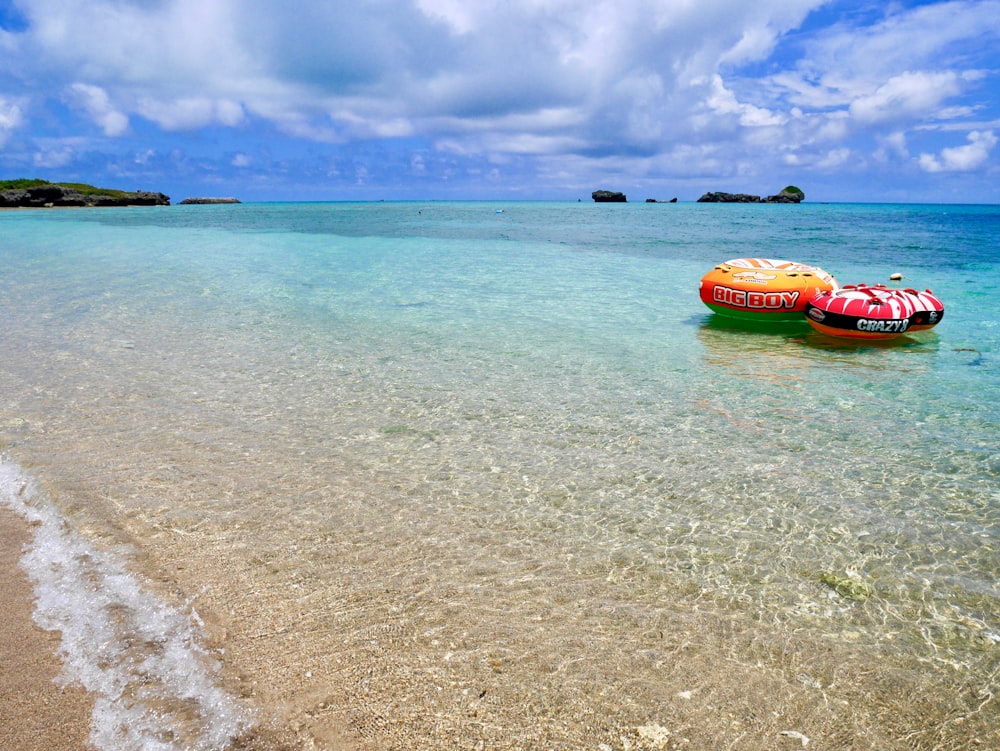 Kayak rojo y amarillo en el mar bajo el cielo azul durante el día