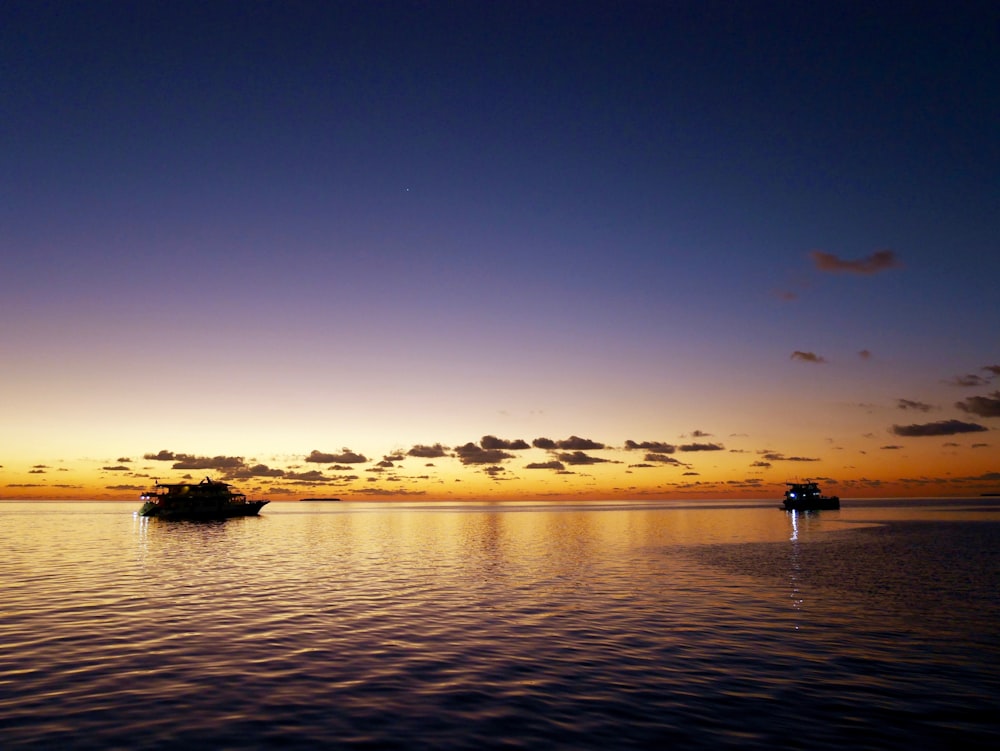 silhouette of people on boat on sea during sunset