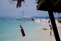 A vibrant beach scene with colorful beachplum lotion bottles resting on a towel.