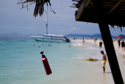 A vibrant beach scene with colorful beachplum lotion bottles resting on a towel.