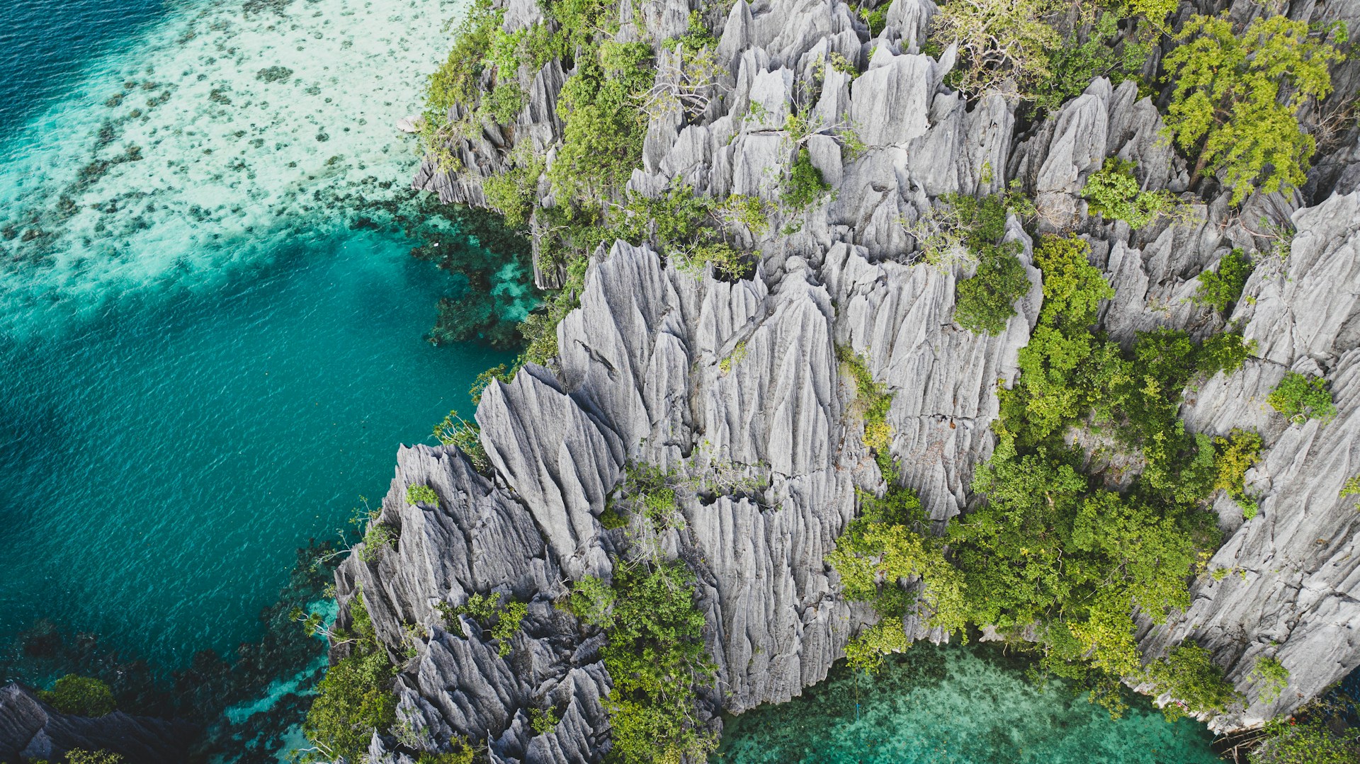 gray rock formation beside body of water during daytime