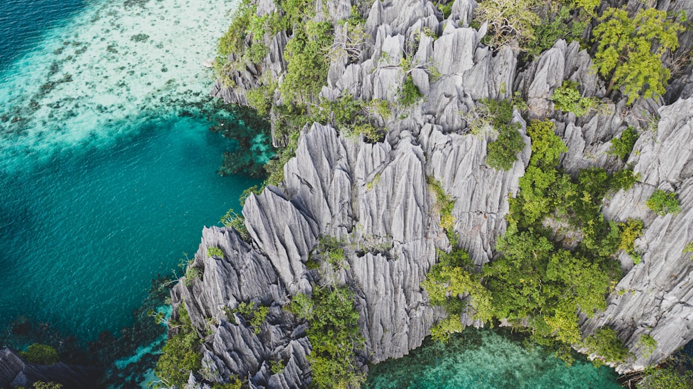 gray rock formation beside body of water during daytime