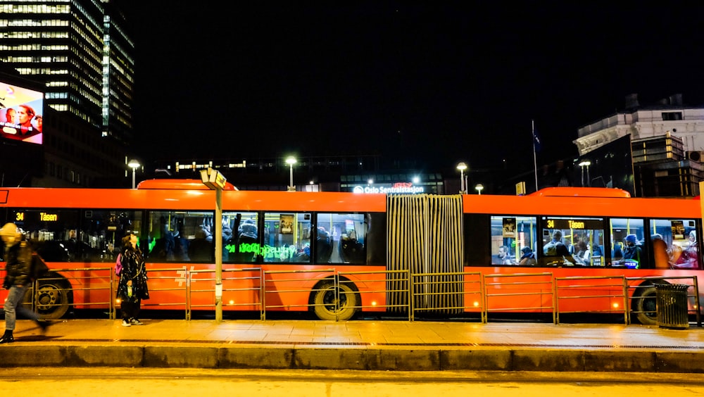 orange and white bus on road during night time