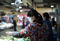 A cheerful person shopping for vegetables in a local market.