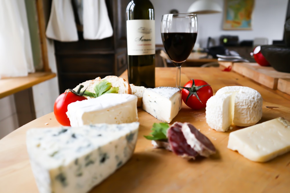 queijo fatiado no pão ao lado da garrafa de vinho