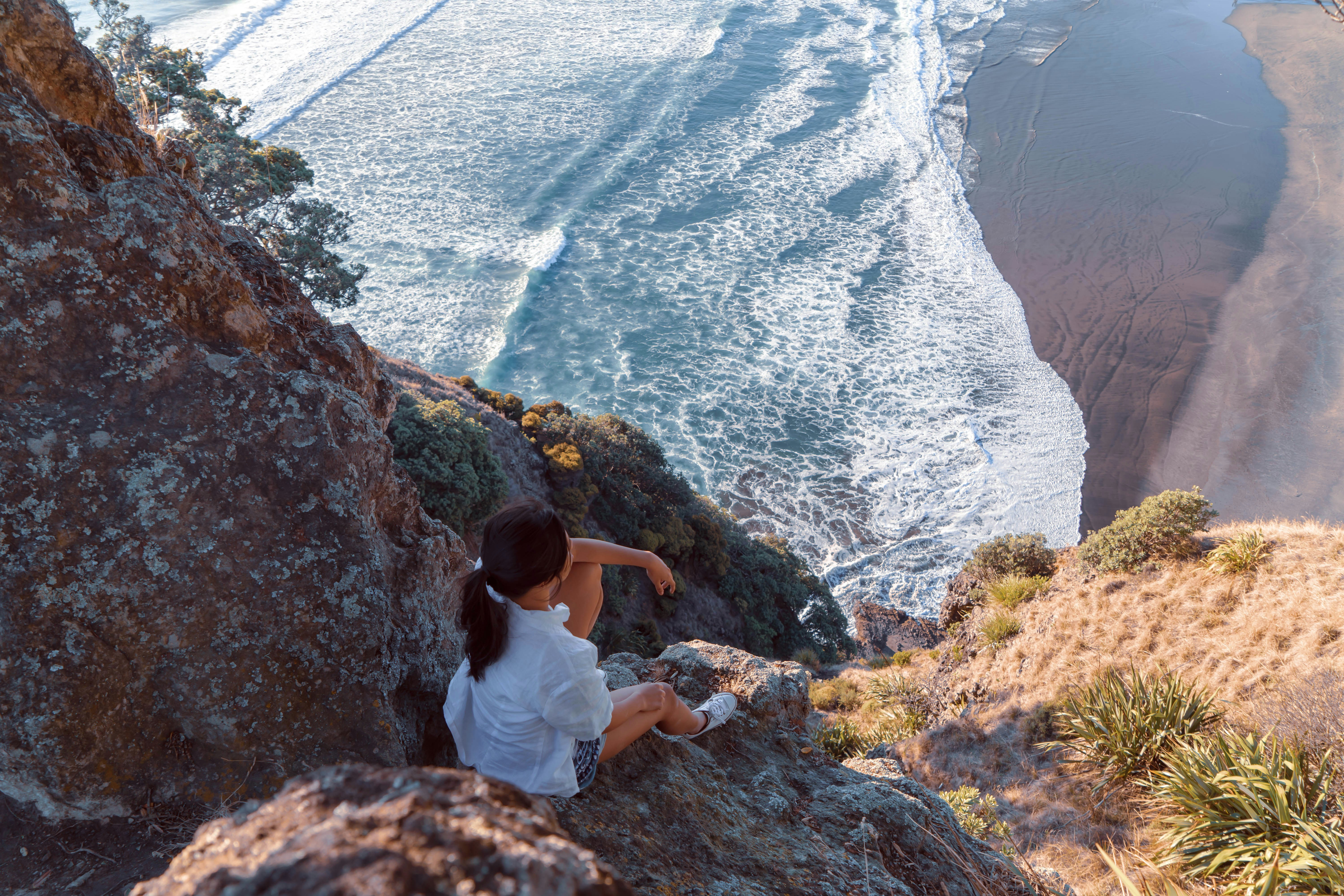 Woman sitting on cliffside