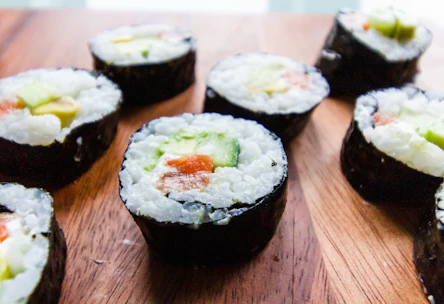 Close-up of colorful sushi rolls arranged on a wooden platter.