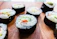 Close-up photo of fresh sushi rolls artfully arranged on a rustic wooden platter.