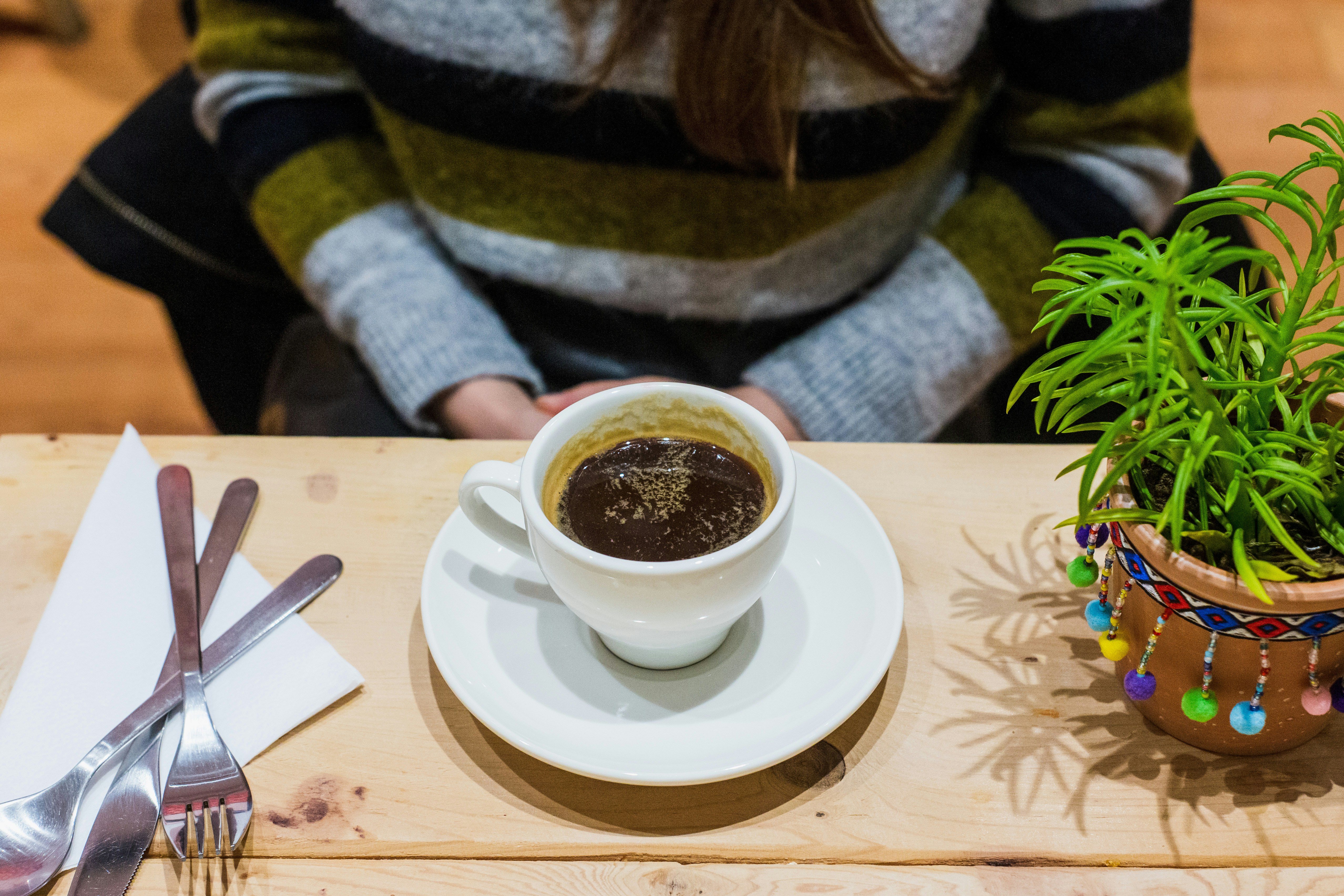 Cup of coffee on a table with a plant