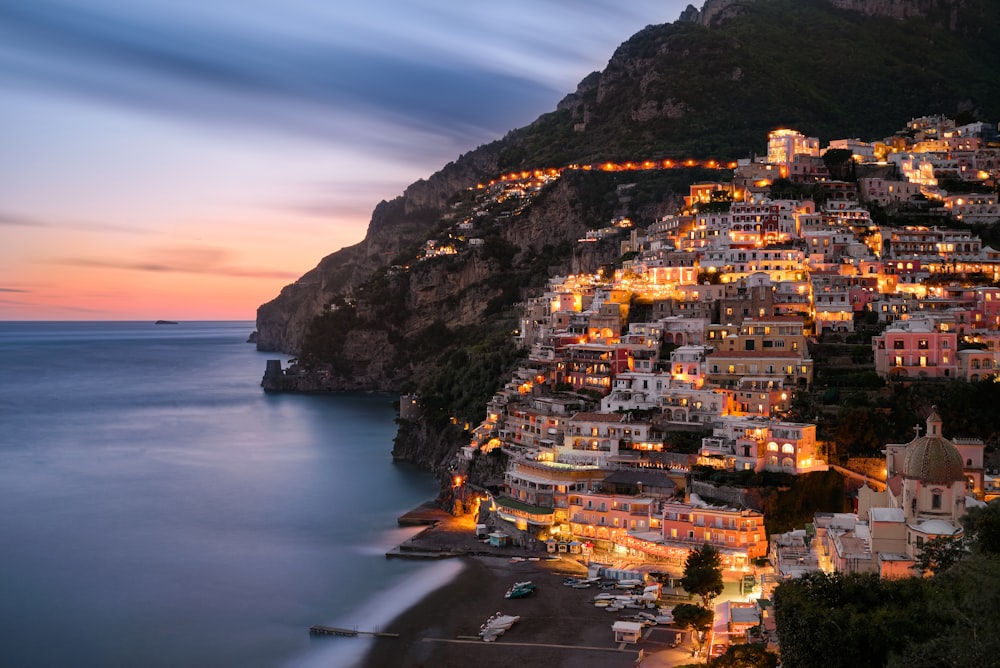 Edifici della città sulla montagna vicino allo specchio d'acqua durante il giorno