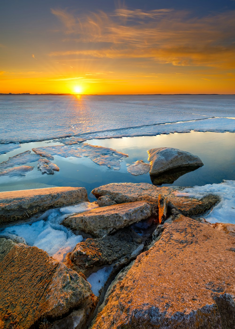 Rivage rocheux avec des vagues d’eau au coucher du soleil
