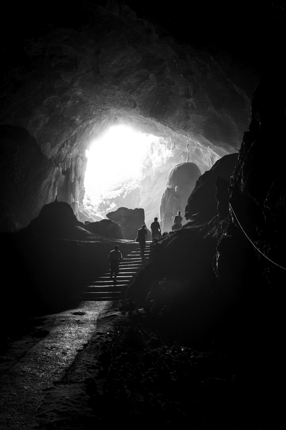 grayscale photo of person walking on tunnel