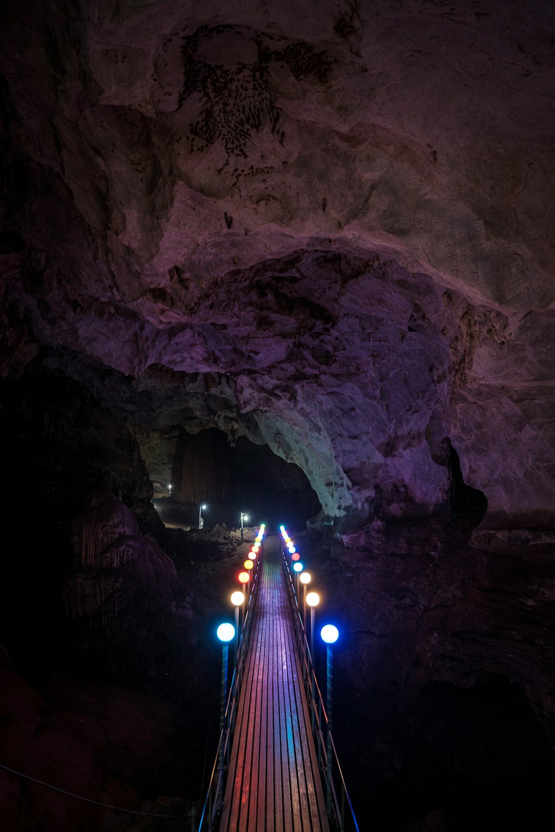lighted bridge in cave during night time