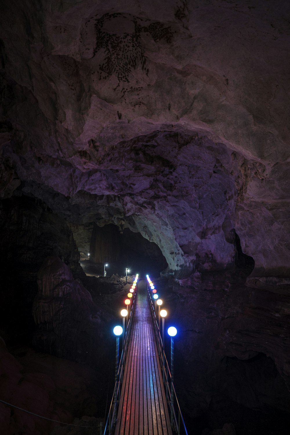 lighted bridge in cave during night time