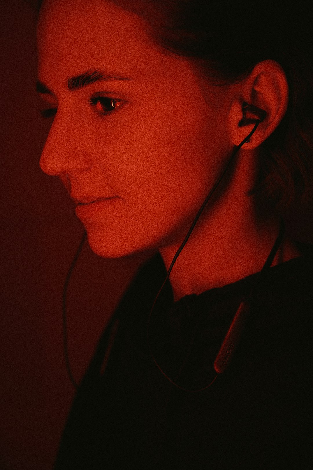 woman in black shirt wearing white earbuds