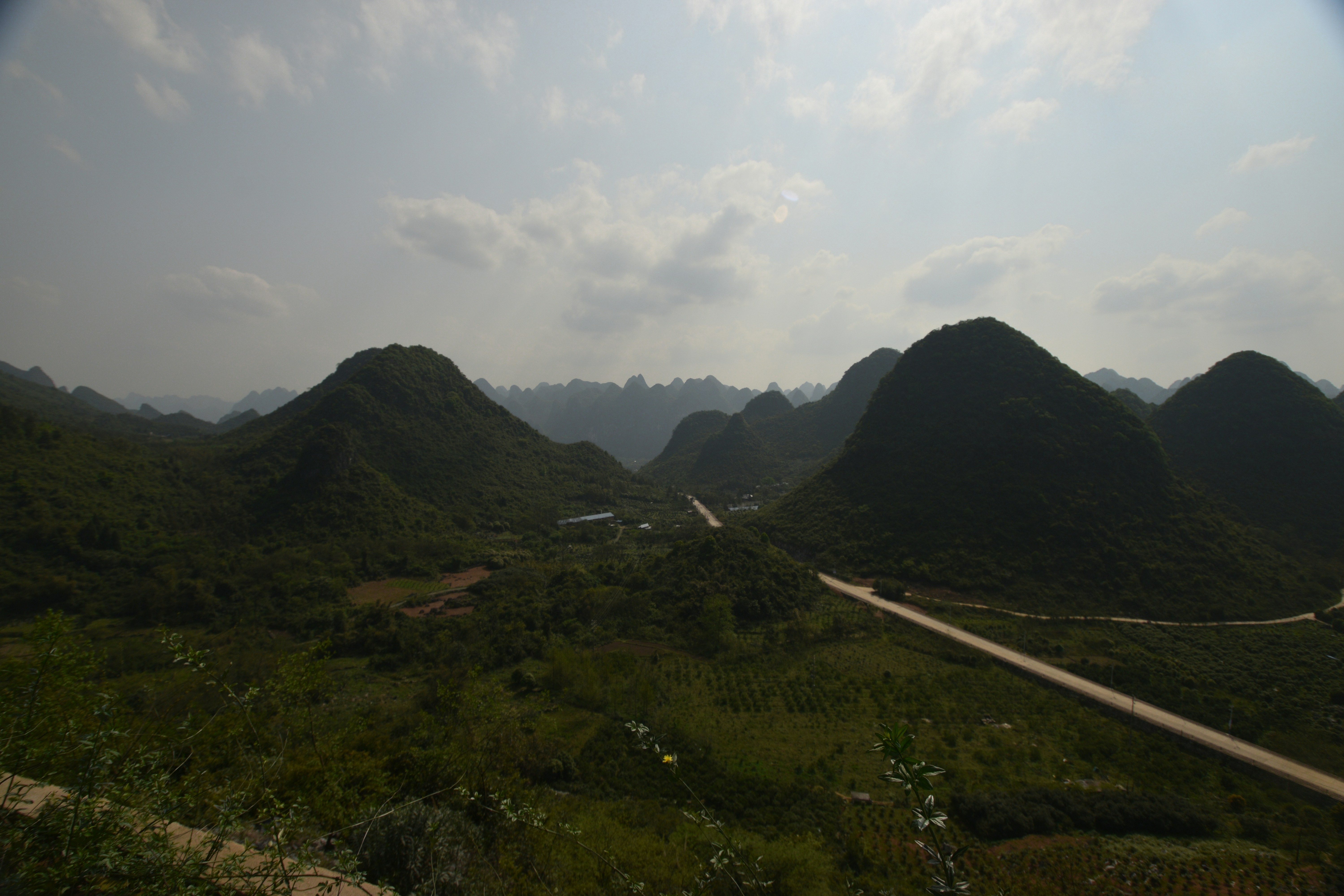green grass field and mountain under white clouds during daytime