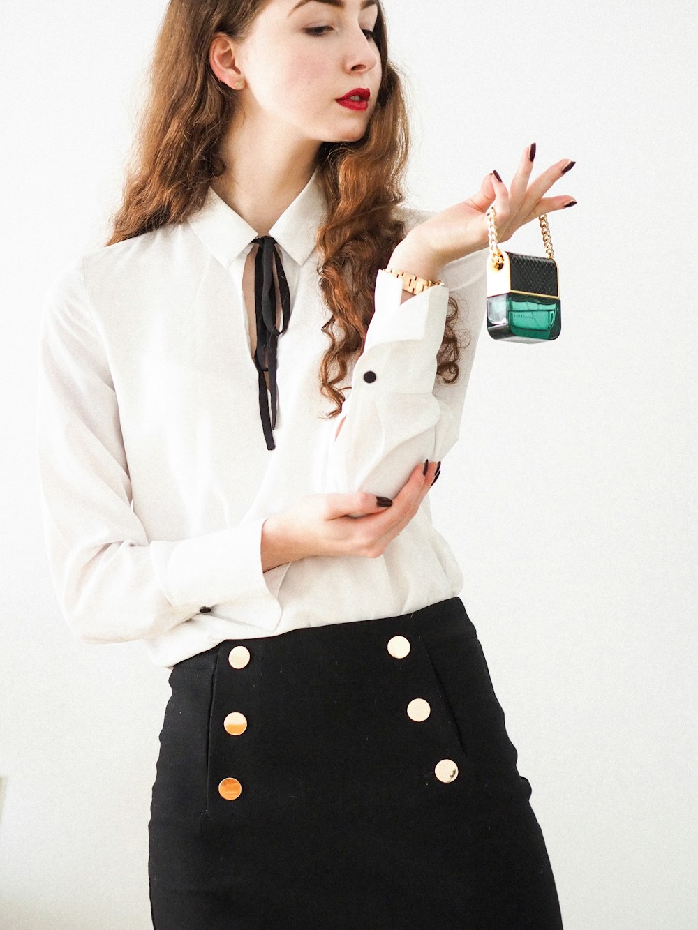 woman in white blazer holding green and white ceramic mug