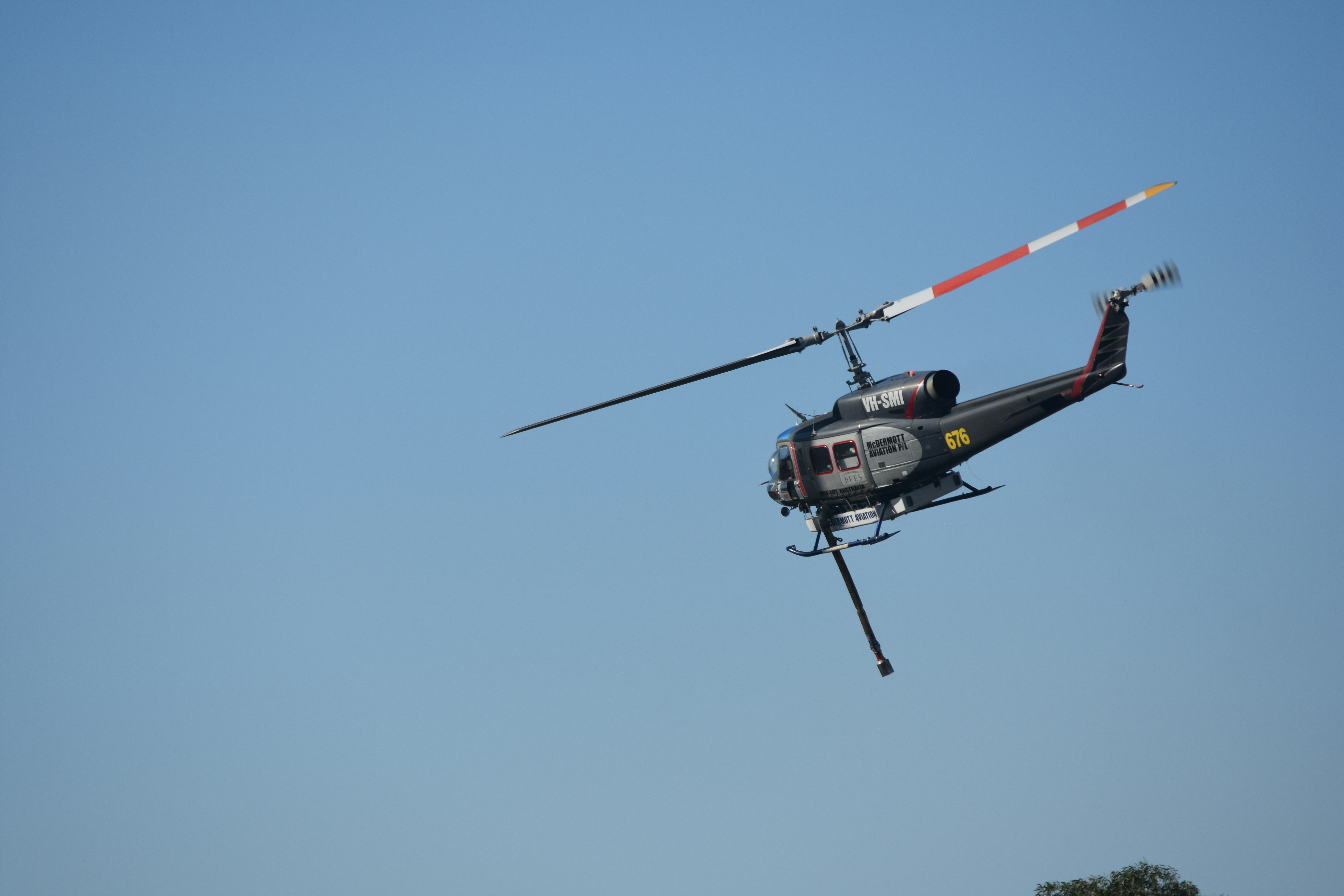helicóptero vermelho e preto voando no céu