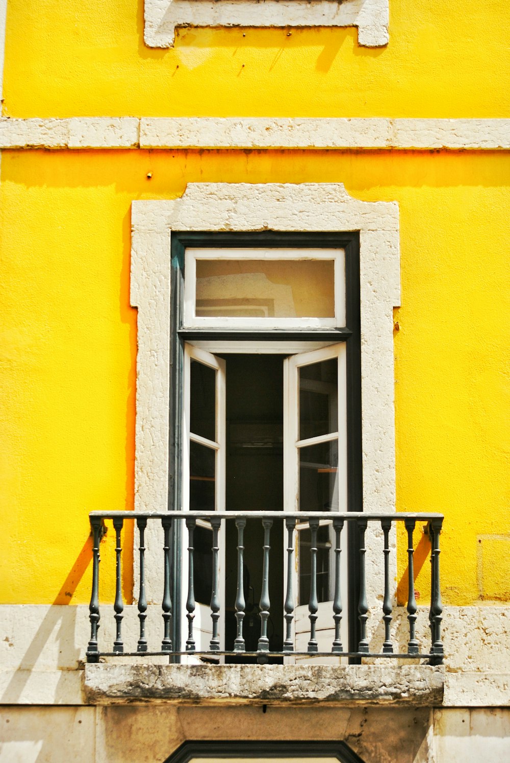 black metal railings on yellow concrete wall