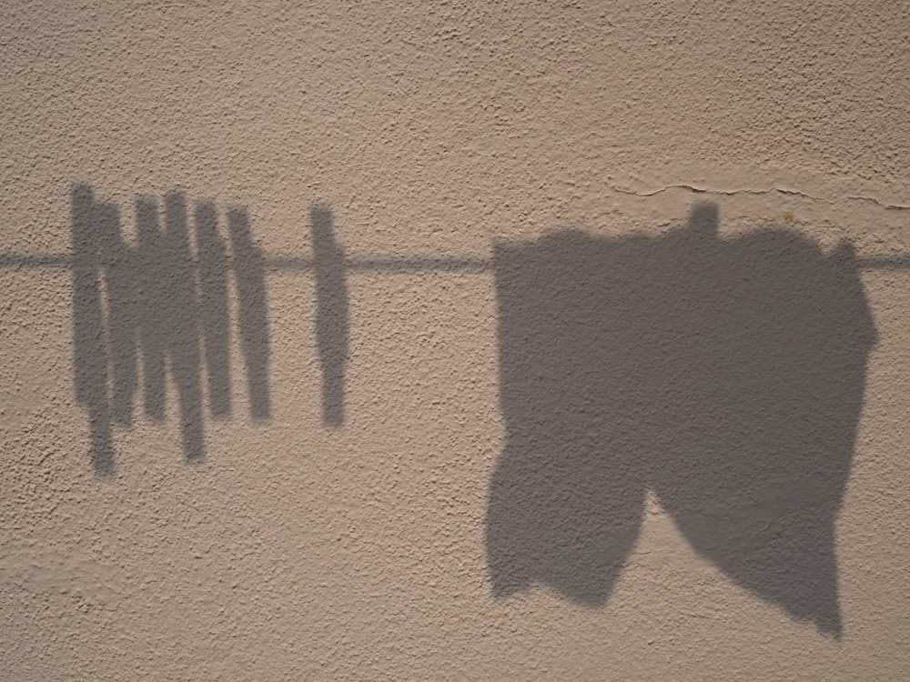 ombre de la personne sur le mur de béton brun