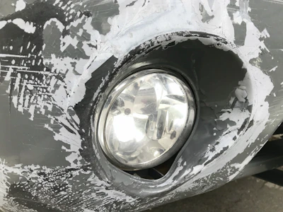 Close-up of a car headlight before restoration, showing cloudiness and wear.