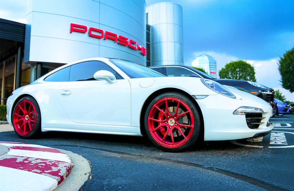 white porsche 911 parked near white and gray concrete building during daytime