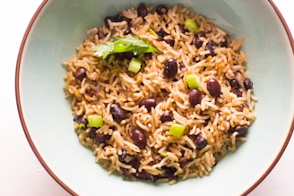 A vibrant plate of red beans and rice garnished with fresh parsley and sliced green onions.