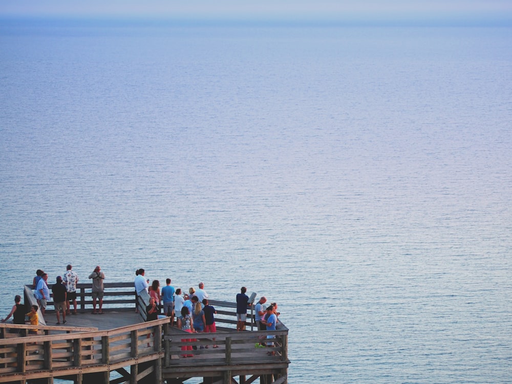 people sitting on wooden dock during daytime