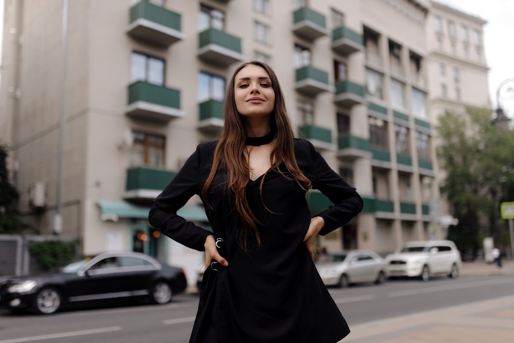 woman in black long sleeve dress standing on road during daytime