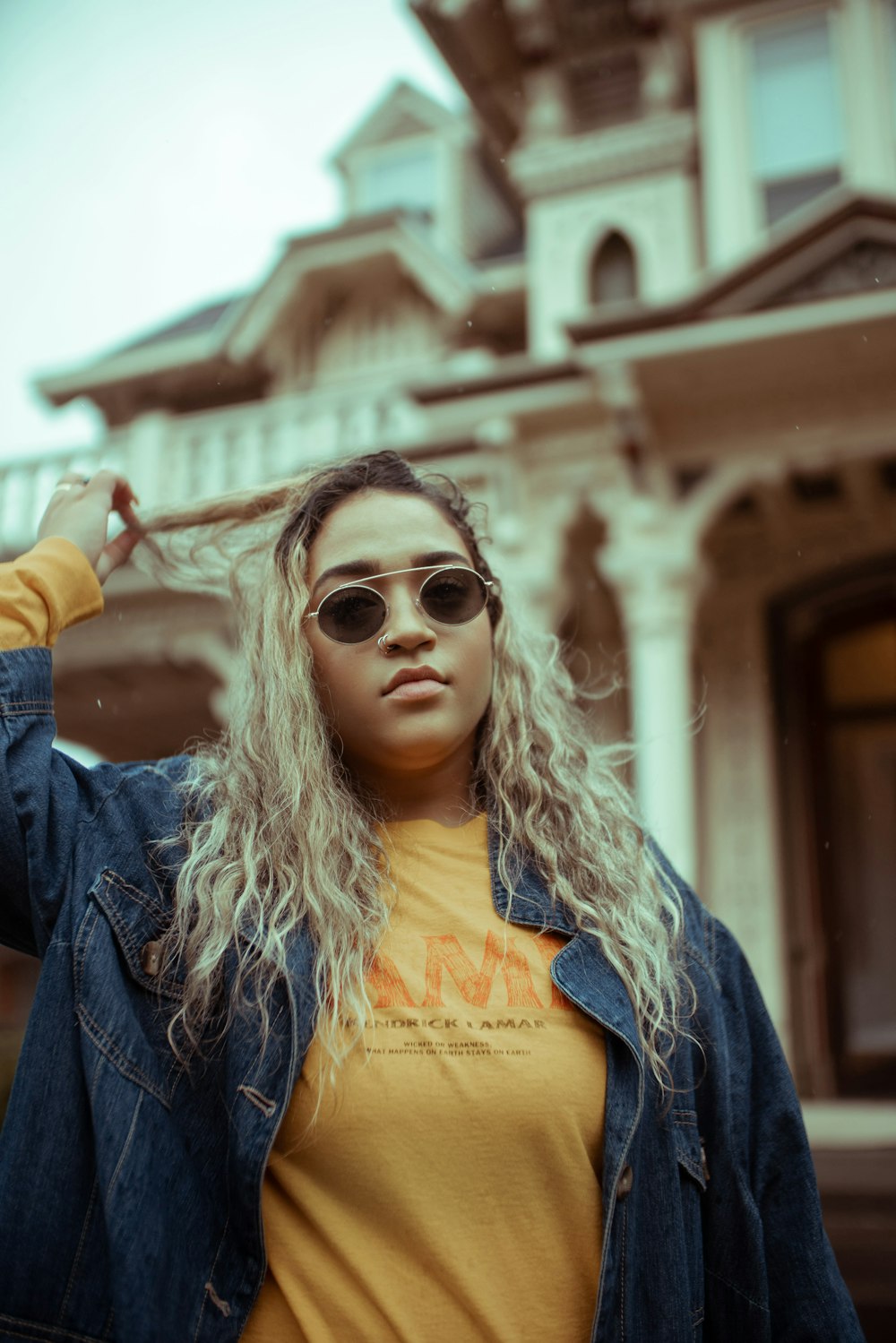 woman in blue denim jacket wearing brown sunglasses