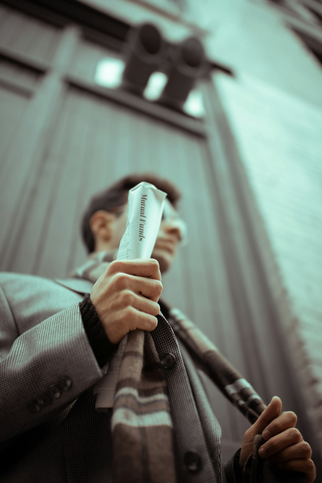 man in gray coat holding white and black stick