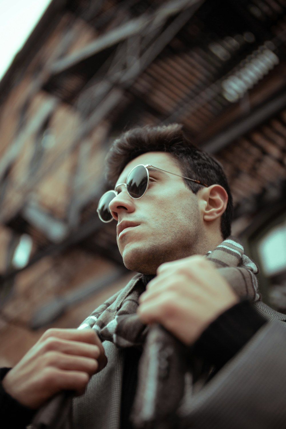 Hombre con gafas de sol negras y chaqueta de camuflaje marrón y beige