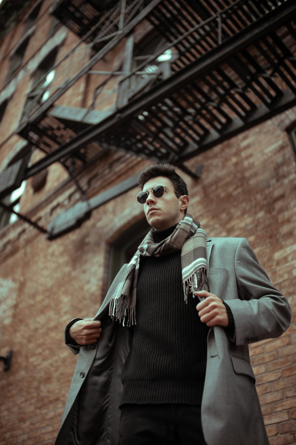 man in gray suit jacket wearing black sunglasses