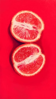 sliced orange fruit on red surface