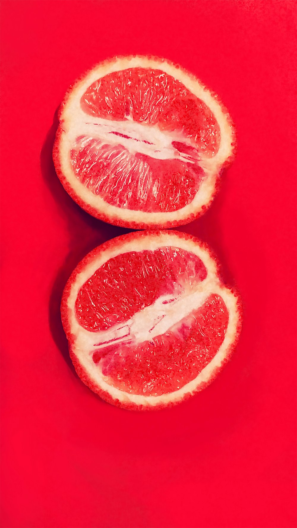 sliced orange fruit on red surface