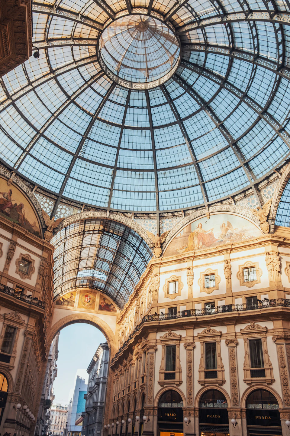 Large ornate glass dome with intricate carvings supports two sturdy columns in open-air mall