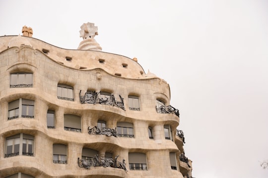 white concrete building under white sky during daytime in Casa Mila Spain