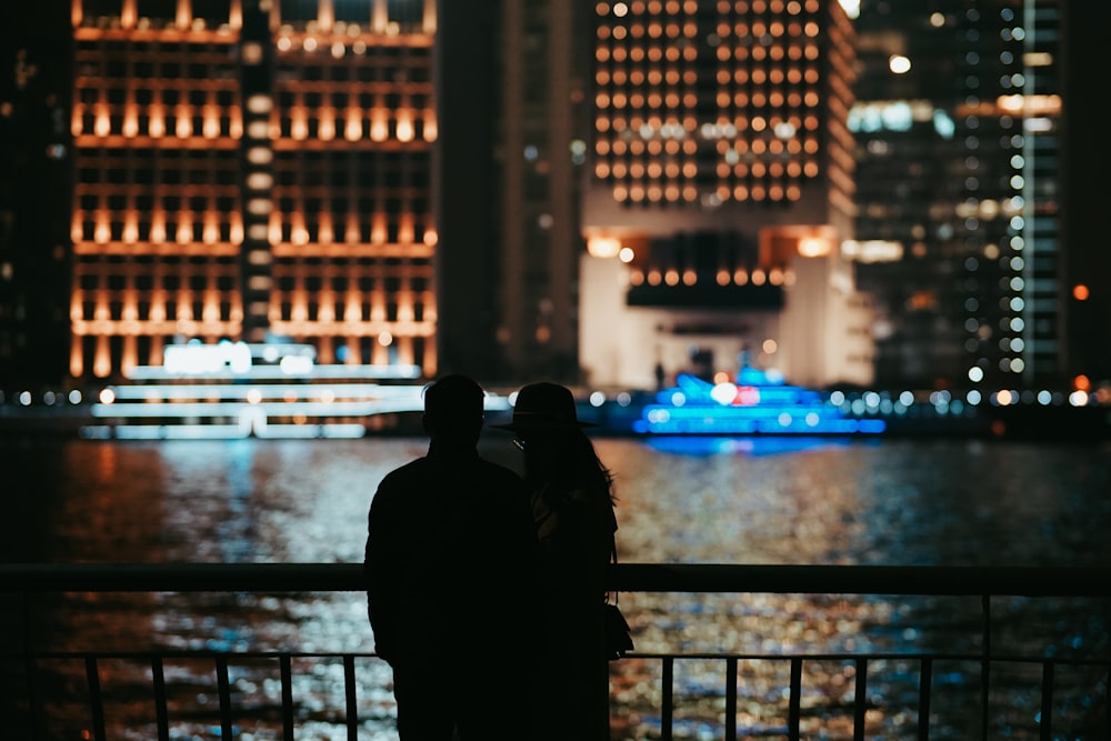 silhouette of person standing near railings during night time