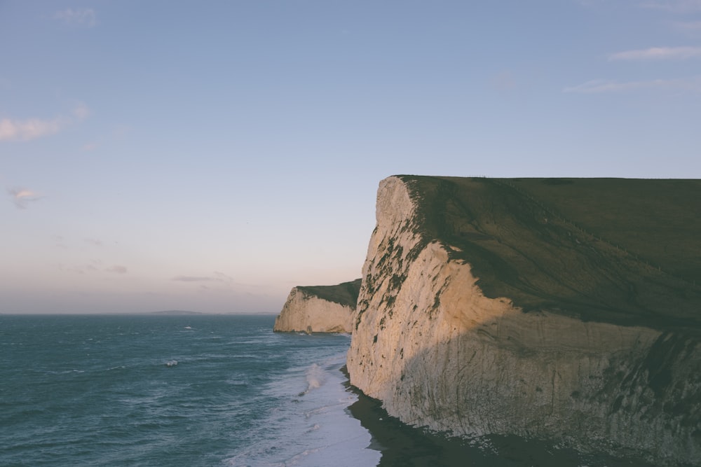 brown rock formation on sea during daytime