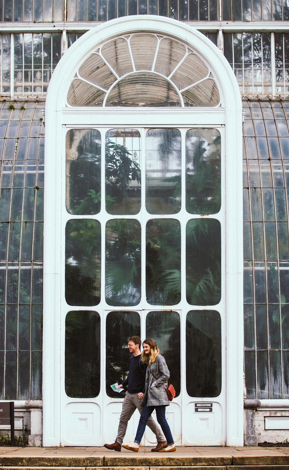 woman in black jacket standing beside glass window