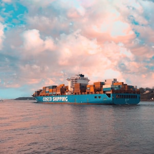 blue cargo ship on sea under cloudy sky during daytime