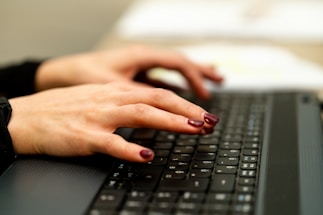 persons hand on black laptop computer