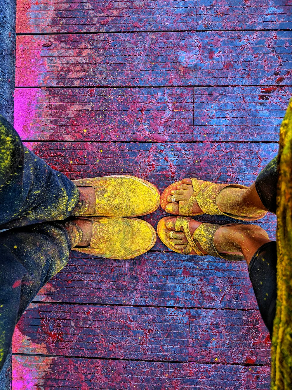 person in black pants and brown shoes standing on red wooden floor