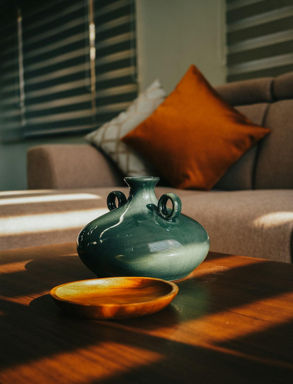 茶色の木製のテーブルに青い陶器の花瓶