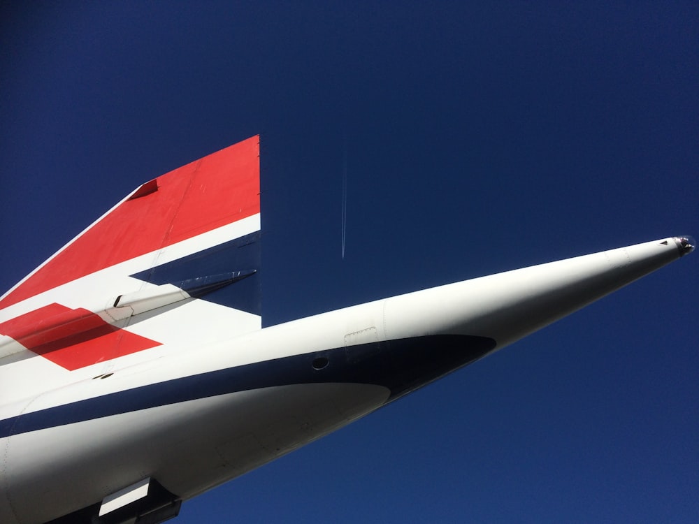 white and red airplane under blue sky during daytime