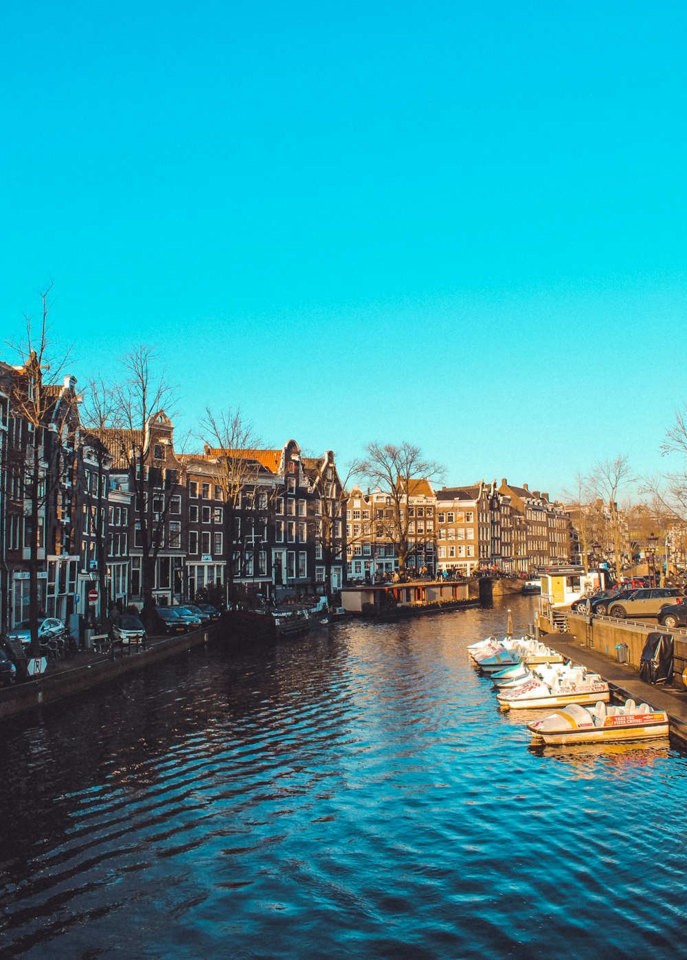 white boat on river between buildings during daytime