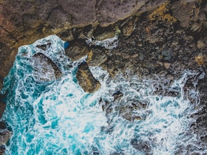 brown rock formation on blue water