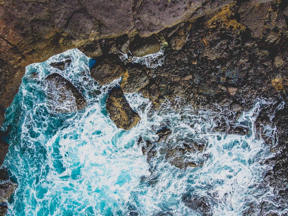 brown rock formation on blue water