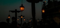 Hanging patio lanterns casting warm light over an inviting outdoor seating area at dusk.