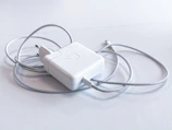 white apple charging adapter on white table